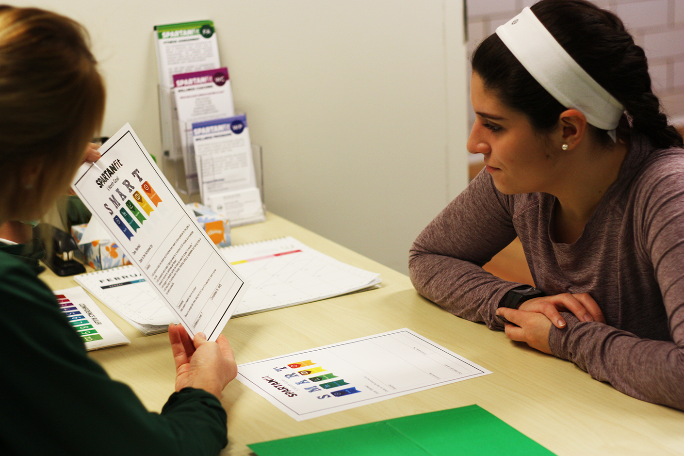 A student meets with a Health Promotion team member to discuss their fitness goals.
